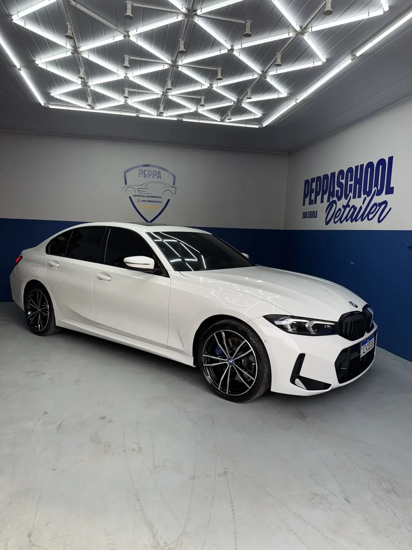 BMW branco no estúdio da Peppa, sob a iluminação geométrica refletida na pintura